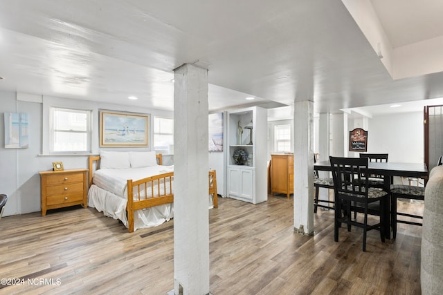 bedroom featuring hardwood / wood-style floors and decorative columns