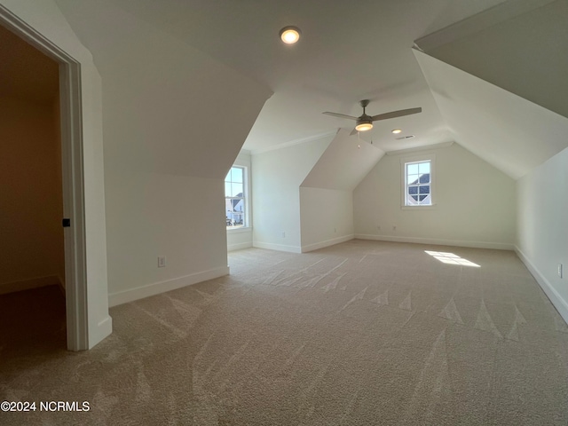 additional living space with lofted ceiling, light colored carpet, and ceiling fan