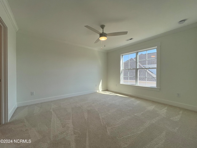 carpeted spare room with crown molding and ceiling fan