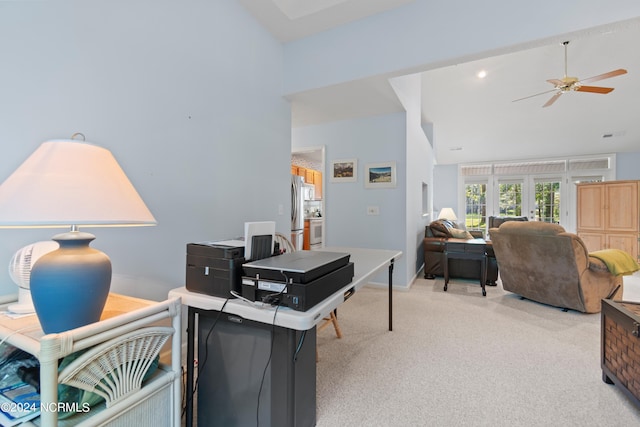 home office with light carpet, high vaulted ceiling, a ceiling fan, and baseboards