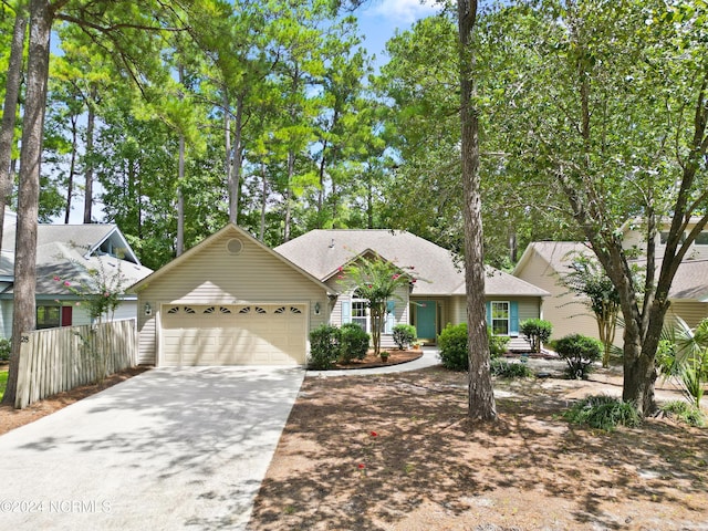 view of front of home with an attached garage, fence, and concrete driveway