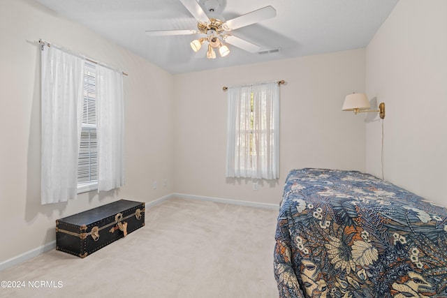 bedroom featuring light carpet, baseboards, visible vents, and ceiling fan