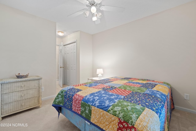 carpeted bedroom with a closet, ceiling fan, and baseboards