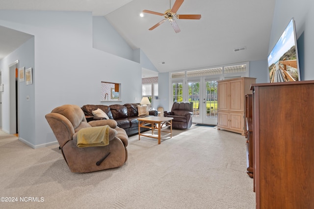 living area with high vaulted ceiling, light colored carpet, visible vents, baseboards, and a ceiling fan