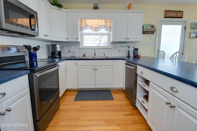 kitchen with light hardwood / wood-style flooring, sink, appliances with stainless steel finishes, and decorative backsplash