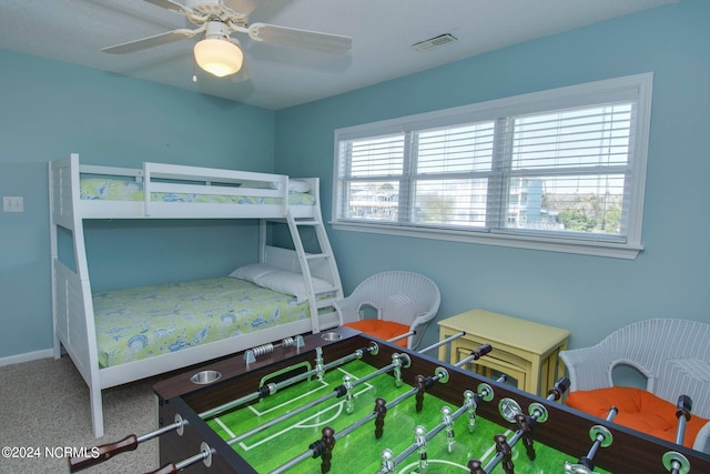 carpeted bedroom with multiple windows and ceiling fan