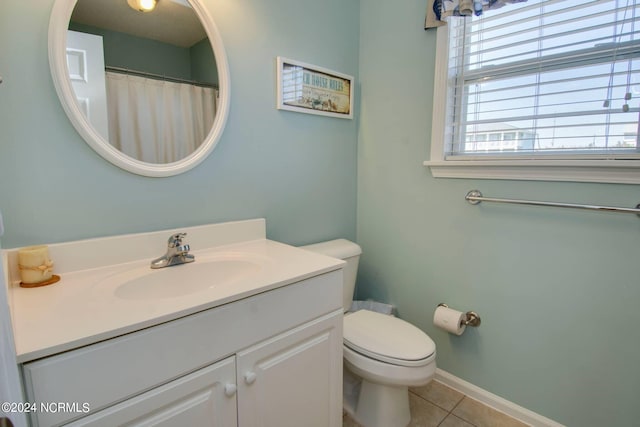 bathroom with tile patterned flooring, vanity, and toilet