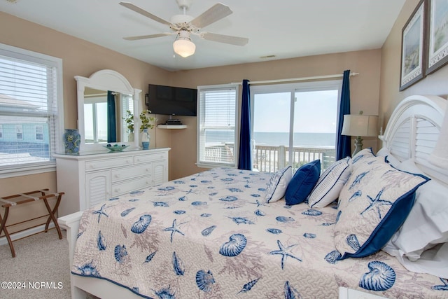 carpeted bedroom featuring multiple windows, ceiling fan, and access to exterior