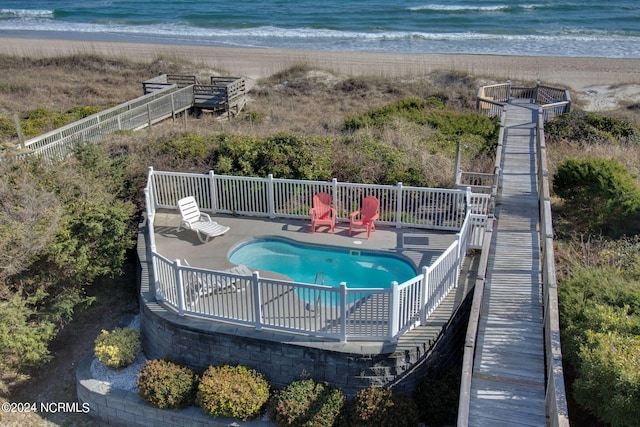 view of swimming pool featuring a beach view and a water view