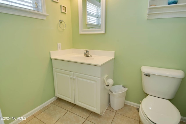 bathroom featuring vanity, toilet, plenty of natural light, and tile patterned floors