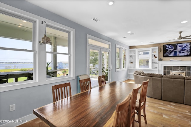 dining space featuring ceiling fan, plenty of natural light, built in features, and light hardwood / wood-style flooring