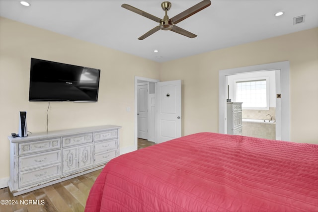 bedroom with light wood-type flooring, ceiling fan, and ensuite bath