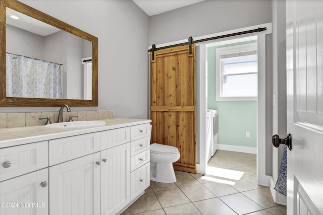 bathroom featuring washer and dryer, toilet, vanity, and tile patterned flooring