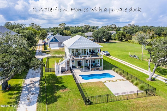 rear view of house with a lawn, a balcony, a patio, and a fenced in pool