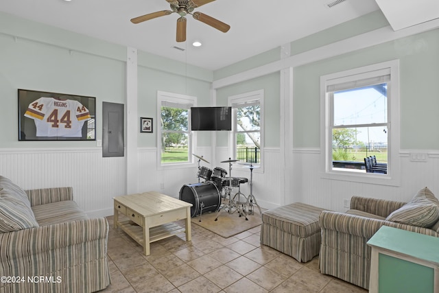 tiled living room featuring ceiling fan and electric panel