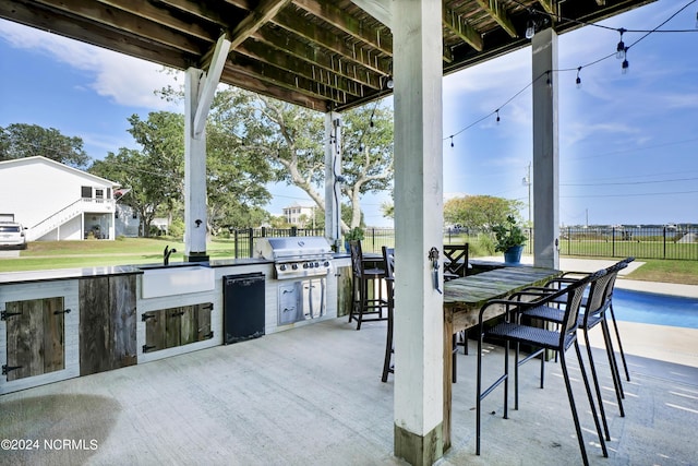 view of patio / terrace with an outdoor kitchen, a wet bar, and grilling area