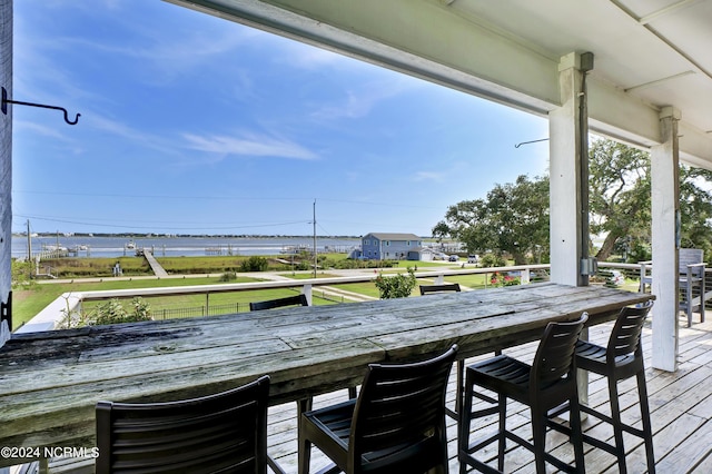 deck with a water view and an outdoor bar