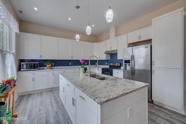 kitchen featuring white cabinetry, stainless steel appliances, tasteful backsplash, hanging light fixtures, and light stone counters