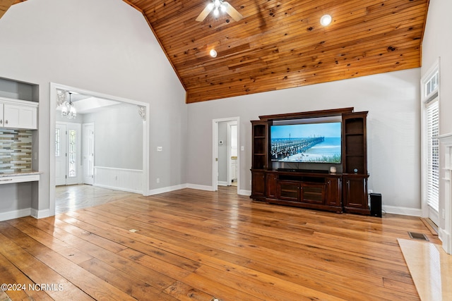 unfurnished living room with ceiling fan with notable chandelier, wood ceiling, high vaulted ceiling, and light hardwood / wood-style floors