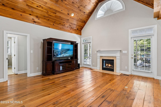 unfurnished living room featuring visible vents, high vaulted ceiling, hardwood / wood-style floors, a high end fireplace, and wooden ceiling