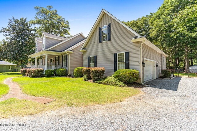 view of front of property with a garage, a porch, and a front lawn