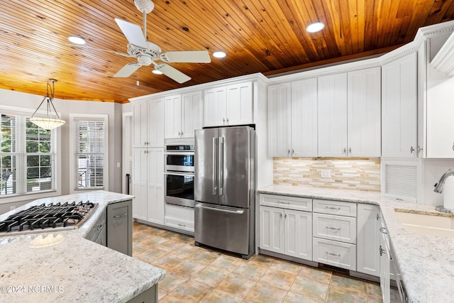 kitchen with pendant lighting, a sink, backsplash, appliances with stainless steel finishes, and white cabinets