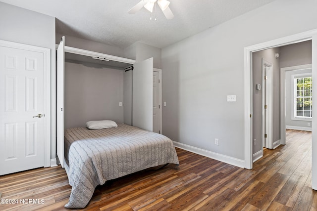 bedroom featuring baseboards, wood finished floors, and a ceiling fan