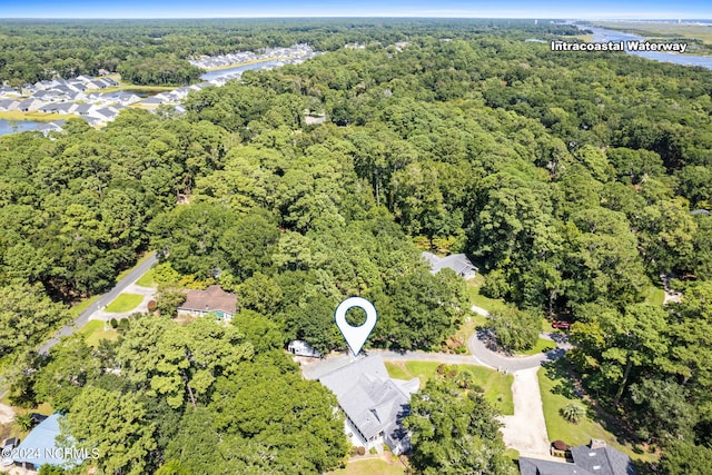 drone / aerial view featuring a wooded view and a water view