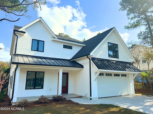 modern farmhouse with a porch and a garage