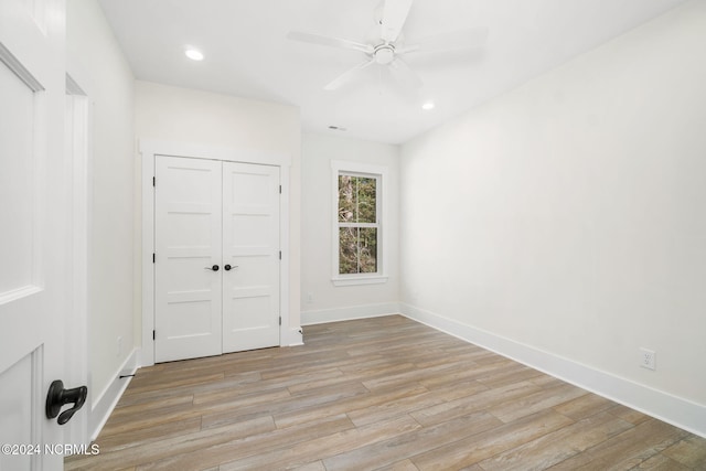 unfurnished bedroom with light wood-type flooring, a closet, and ceiling fan