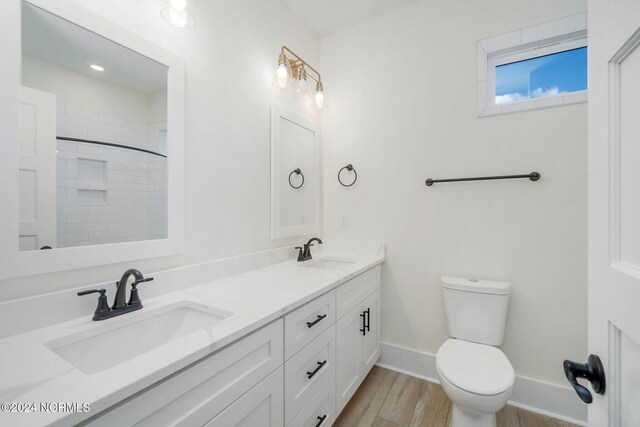 bathroom with vanity, hardwood / wood-style flooring, toilet, and walk in shower