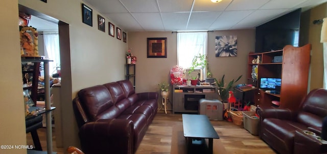 living room featuring a drop ceiling and wood finished floors