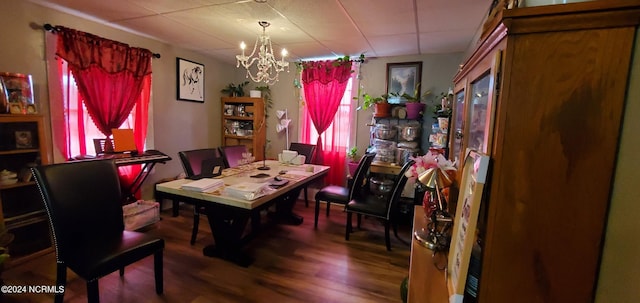 dining space with wood finished floors and an inviting chandelier