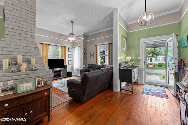 living area featuring hardwood / wood-style floors, ceiling fan with notable chandelier, and ornamental molding