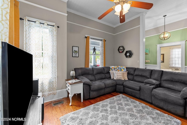 living area featuring crown molding, wood finished floors, ceiling fan, and visible vents