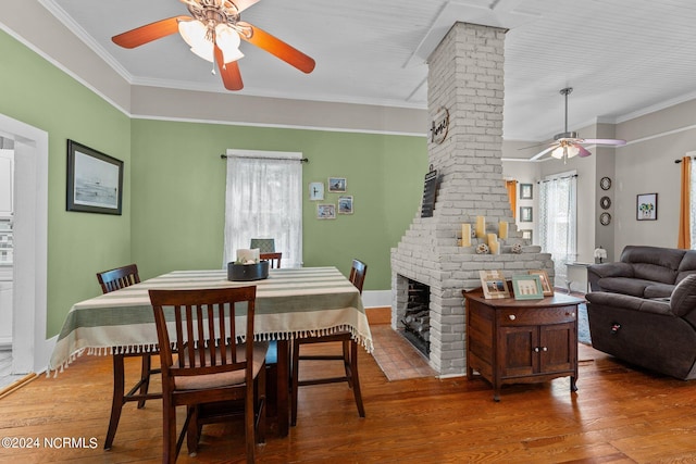 dining area featuring decorative columns, hardwood / wood-style flooring, a ceiling fan, and ornamental molding