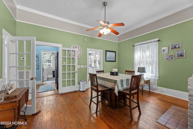 dining room featuring baseboards, french doors, crown molding, ceiling fan, and hardwood / wood-style flooring