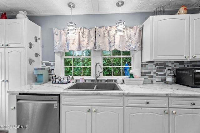 kitchen featuring white cabinets, dishwasher, hanging light fixtures, and sink