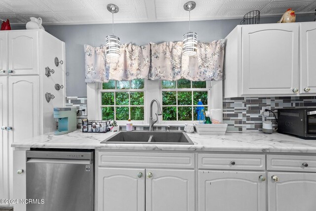 kitchen with stainless steel dishwasher, white cabinets, a sink, decorative backsplash, and an ornate ceiling