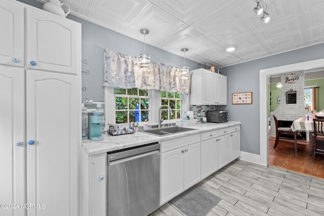 kitchen featuring white cabinets, hanging light fixtures, sink, dishwasher, and light wood-type flooring