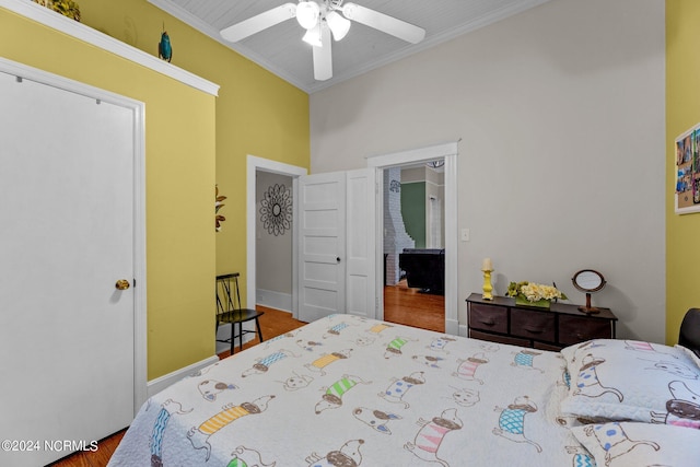 bedroom featuring baseboards, crown molding, a ceiling fan, and wood finished floors
