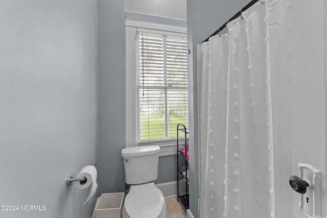 bathroom featuring walk in shower and toilet