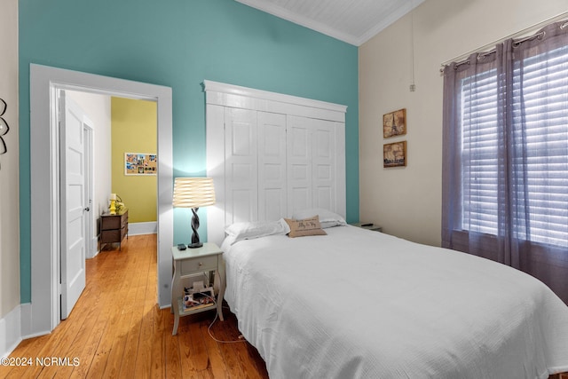 bedroom with crown molding, a closet, and hardwood / wood-style flooring