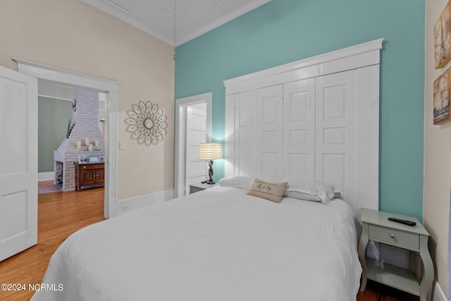 bedroom with light wood-type flooring, a closet, and ornamental molding