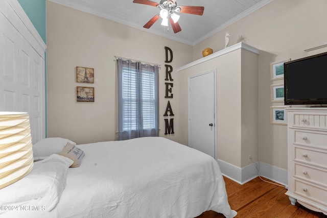 bedroom with a closet, ceiling fan, hardwood / wood-style floors, and crown molding