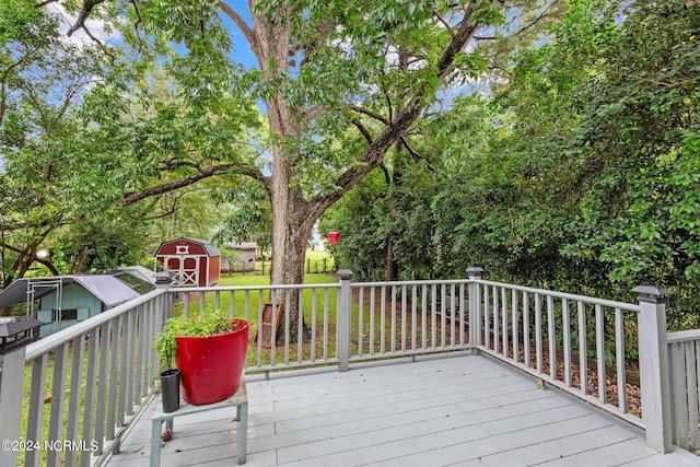 wooden deck with a storage unit and a yard