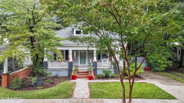 view of front of property with a shingled roof and covered porch