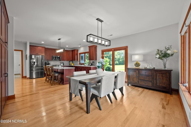 dining room with baseboards, light wood-type flooring, visible vents, and recessed lighting