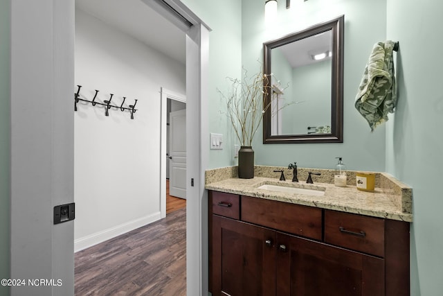 bathroom featuring baseboards, wood finished floors, and vanity