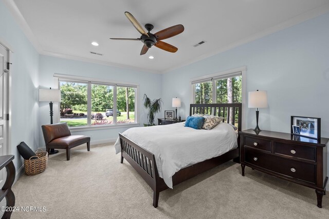 carpeted bedroom with ceiling fan and ornamental molding